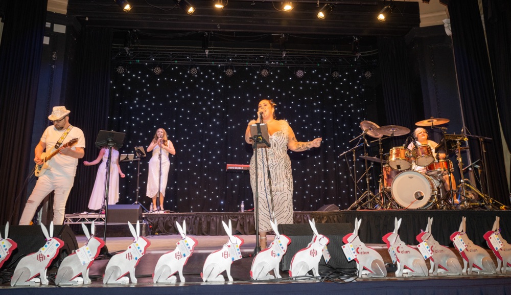 Live band performing on stage with decorative rabbits.
