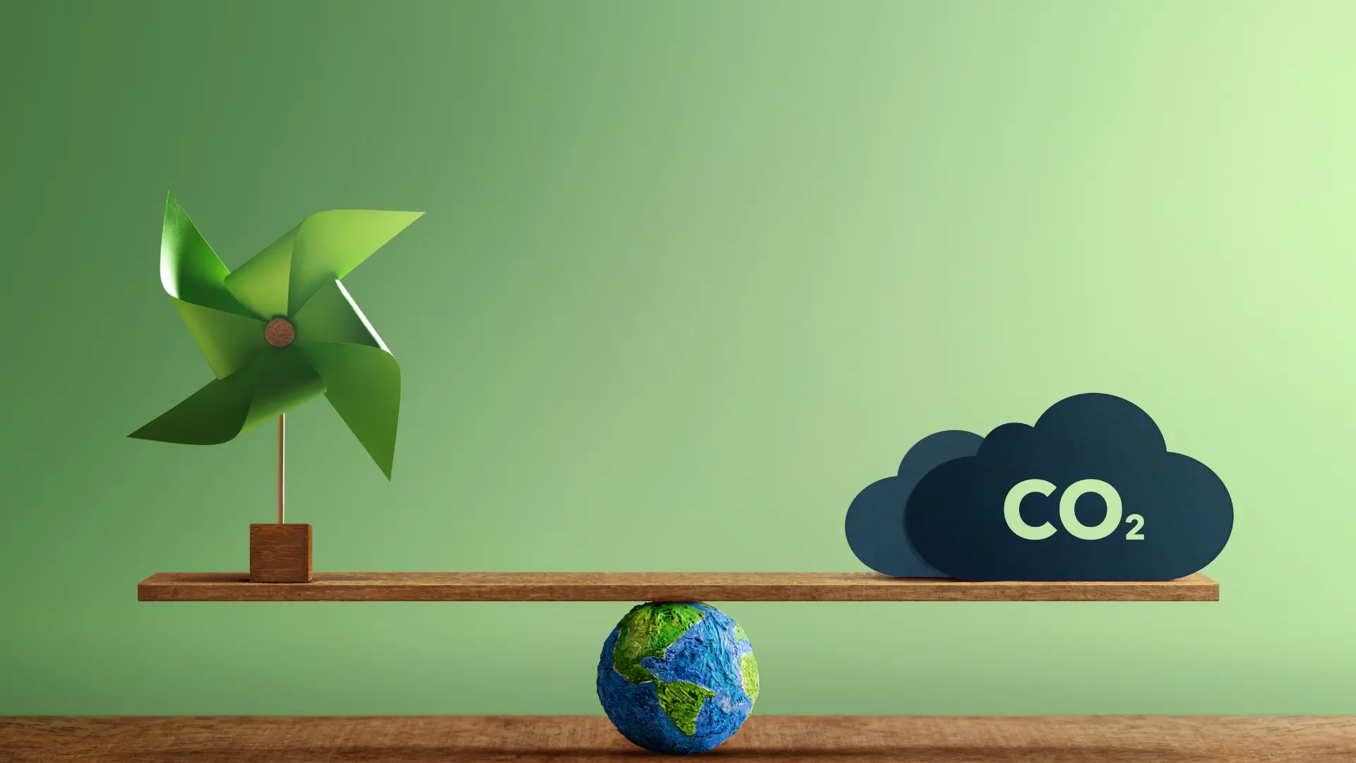 Green pinwheel, globe, 'CO2' cloud balancing on seesaw