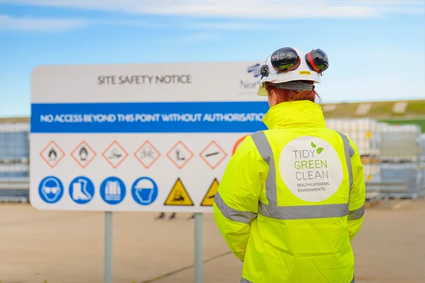 Rapid response worker viewing construction site safety notice board in Scotland